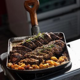 Grilled steak served in a pan with potatoes